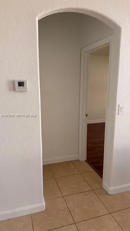 a view of a room with wooden floor and a ceiling fan