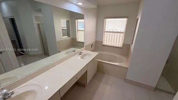 a white bath tub sitting in a bathroom next to a window