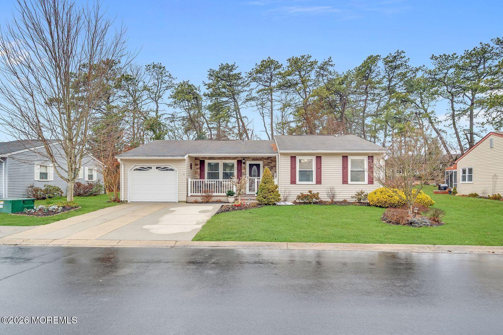 7 Eaton Lane, Unit 73 Whiting, NJ 08759 - Photo 3 of 37 a front view of a house with a garden and trees