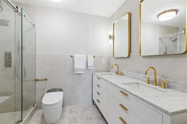 a bathroom with a granite countertop sink toilet and shower