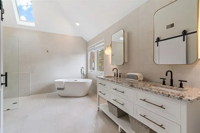 a bathroom with a granite countertop sink mirror and bathtub