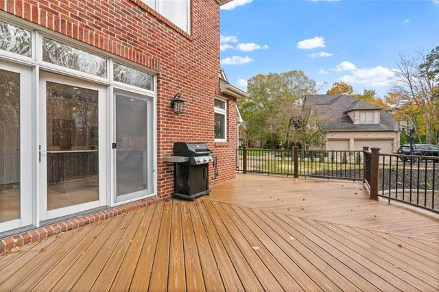 a view of a house with a barbeque and wooden floor
