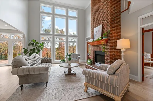 a living room with furniture fireplace and a large window