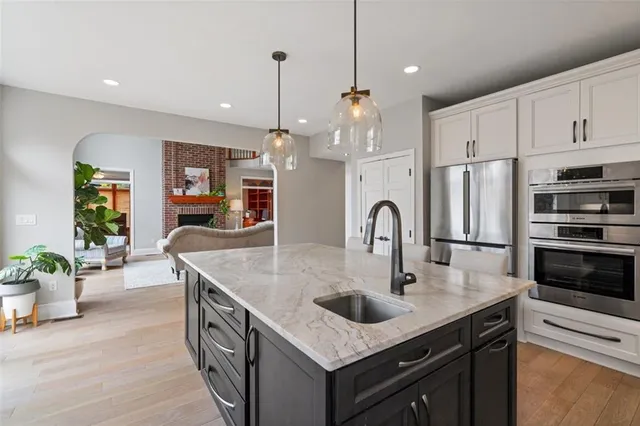 a kitchen with stainless steel appliances granite countertop a sink a stove and a refrigerator
