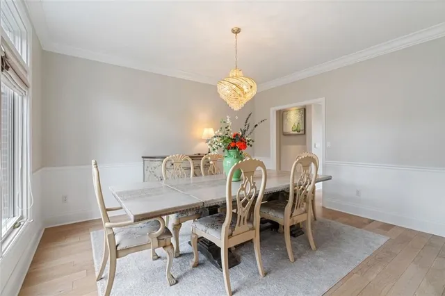 a dining room with furniture a chandelier and wooden floor