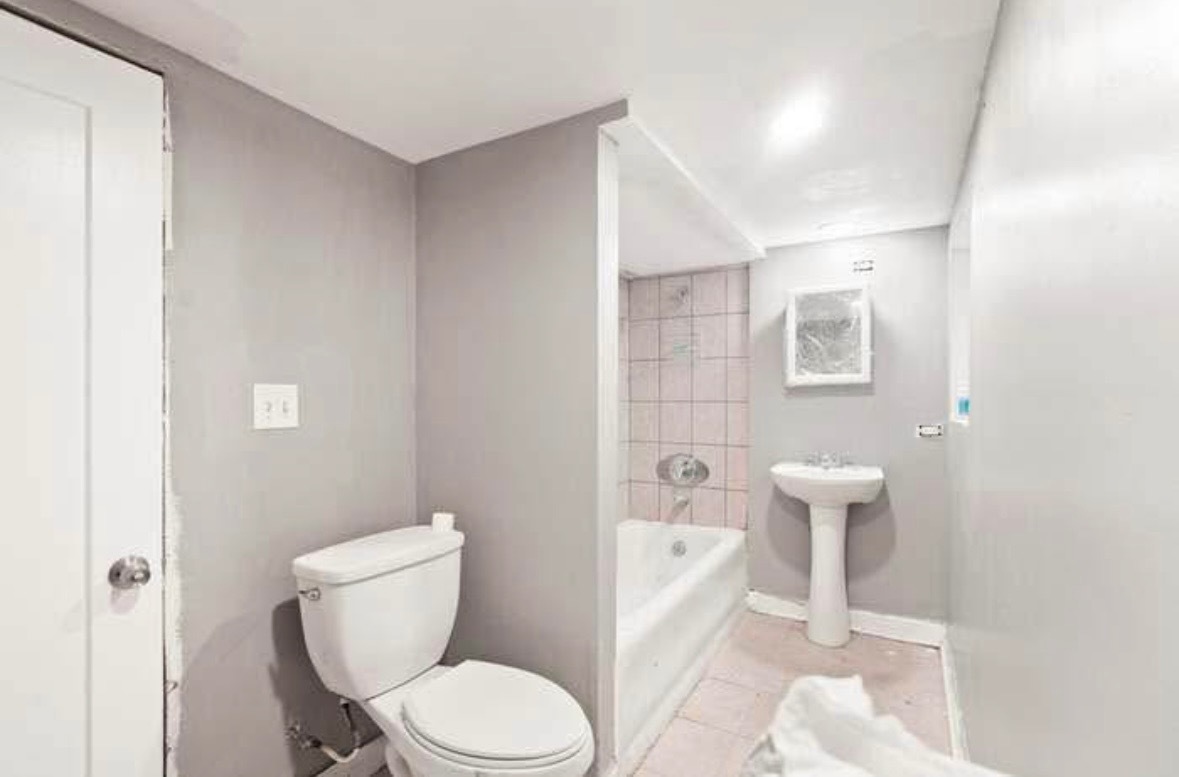 6918 South Talman Avenue, Unit G Chicago, IL 60629 - Photo 6 of 7 a white toilet sitting next to a bathroom sink and a shower