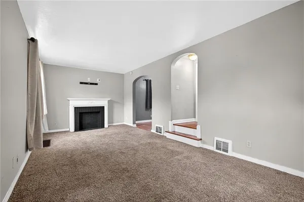 a view of an empty room with a fireplace