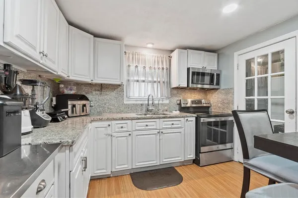a kitchen with granite countertop a sink stove and cabinets