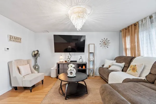a living room with furniture a flat screen tv and a window