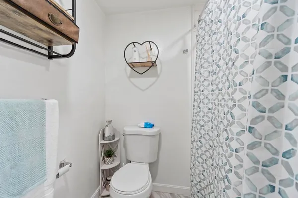 a bathroom with a toilet and a shower curtain