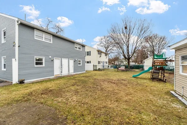a view of a house with a backyard and a tree