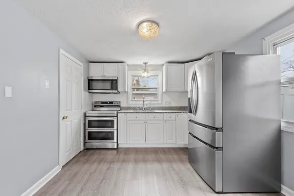a kitchen with a refrigerator and a stove top oven