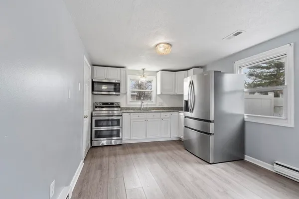 a kitchen with a refrigerator and a stove top oven