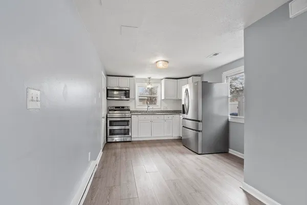 a kitchen with a refrigerator and a stove top oven
