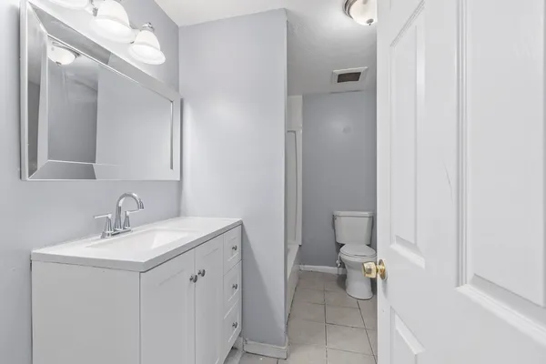 a bathroom with a sink a toilet and a mirror