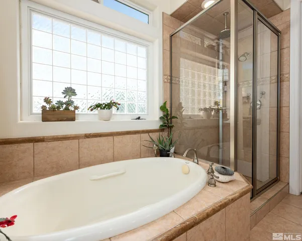 a spacious bathroom with a granite countertop sink a mirror and shower