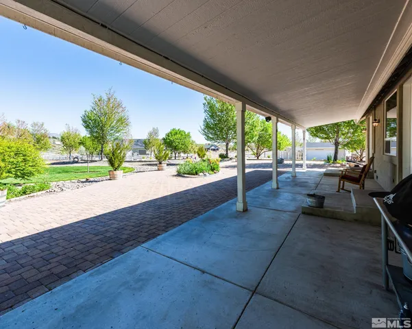 a front view of a house with a yard and potted plants