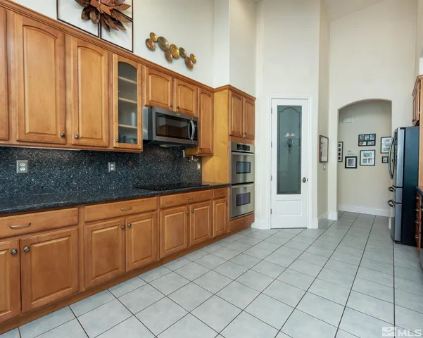 a kitchen with stainless steel appliances granite countertop a refrigerator and a sink
