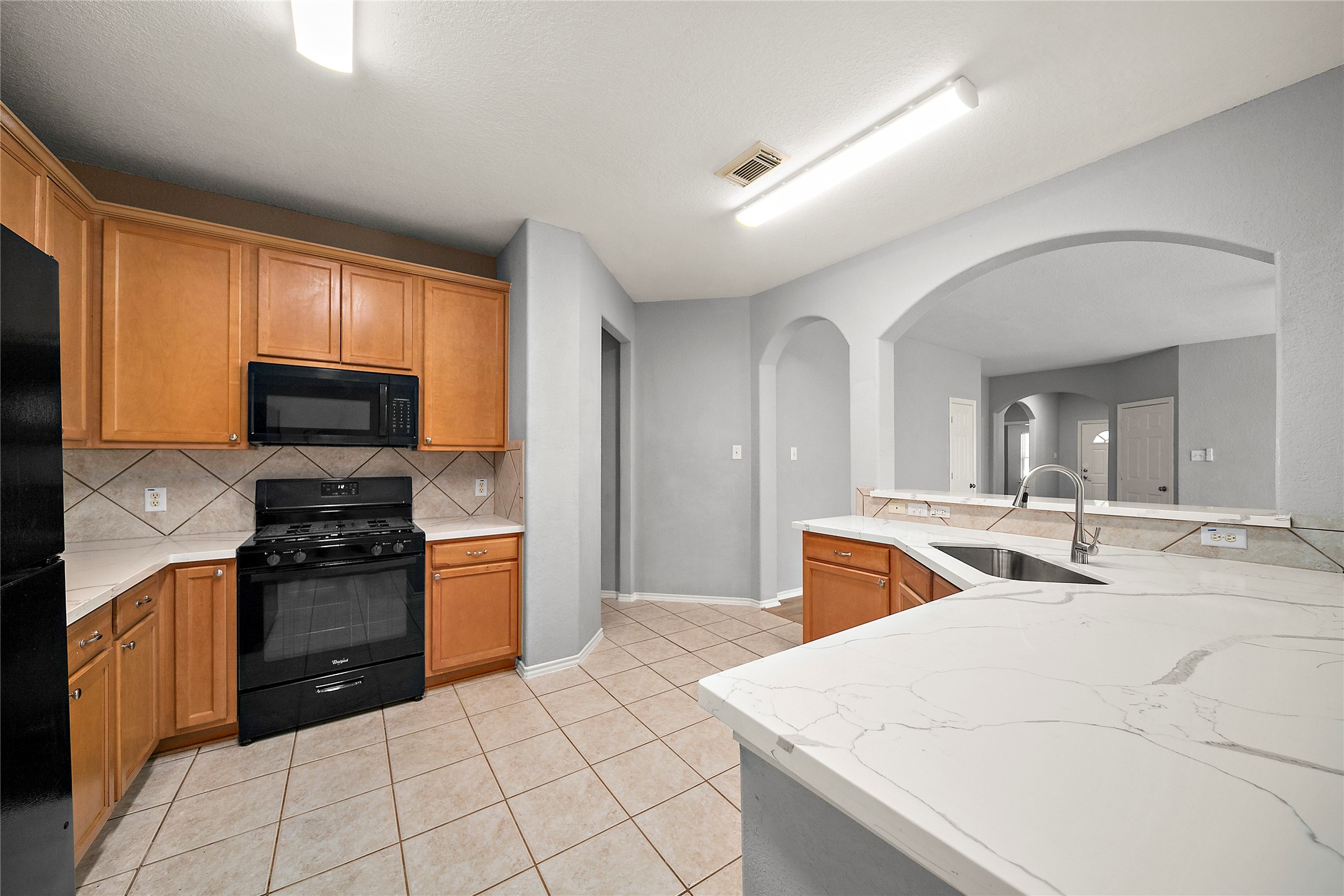 62 Rookwood Court The Woodlands, TX 77382 - Photo 8 of 24 a kitchen with a stove a sink and a microwave