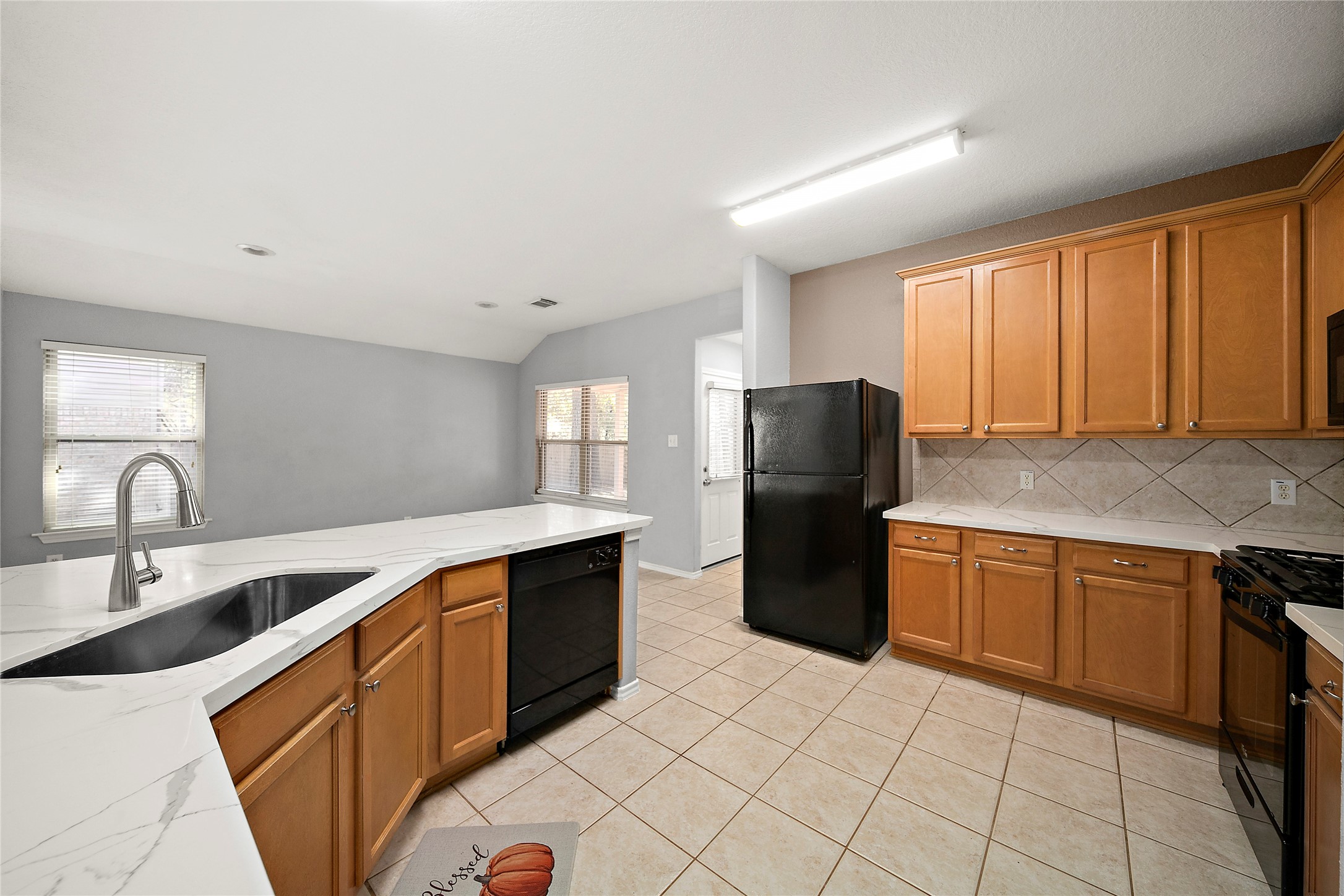 62 Rookwood Court The Woodlands, TX 77382 - Photo 9 of 24 a kitchen with stainless steel appliances granite countertop a refrigerator and a sink