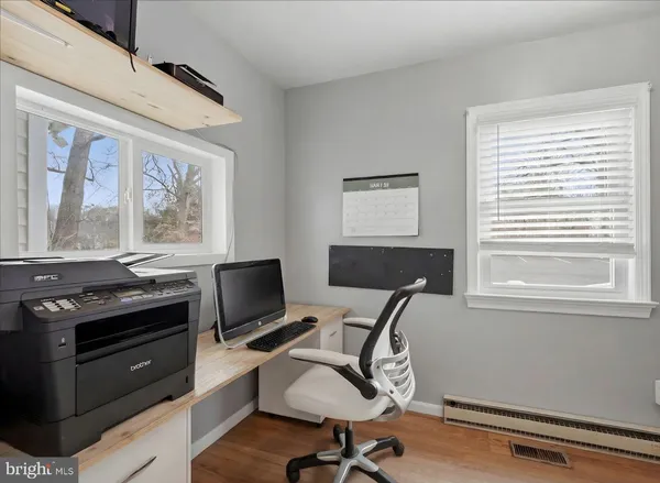 a view of a workspace with furniture and a window