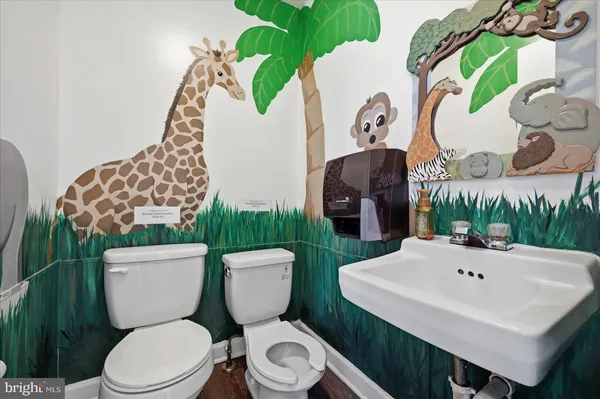 a white toilet sitting next to a bathroom sink and a mirror