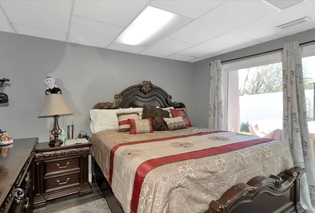 a bedroom with a bed and a lamp on the dresser