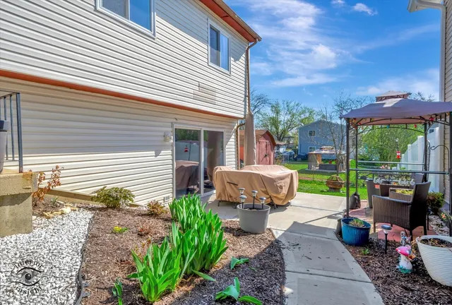 a view of a patio with table and chairs potted plants and floor to ceiling window