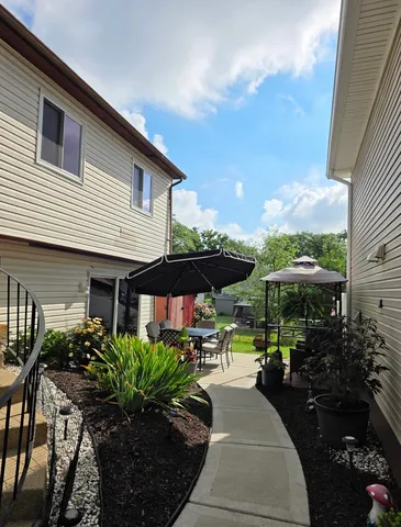 a patio with a table and chairs under an umbrella