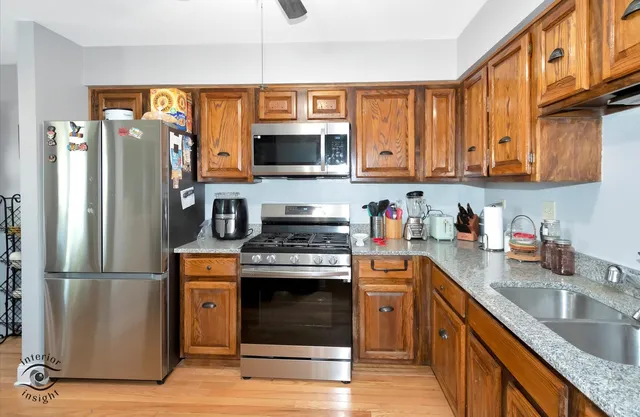 a kitchen with stainless steel appliances granite countertop a refrigerator stove top oven a sink and dishwasher