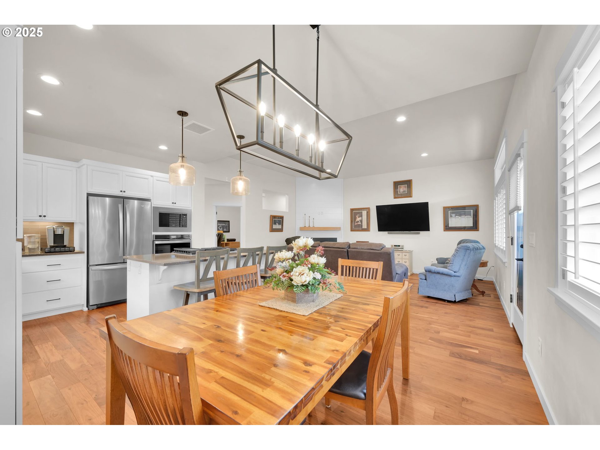970 Lupine Street Springfield, OR 97477 - Photo 18 of 47 a kitchen with stainless steel appliances kitchen island granite countertop a refrigerator a stove a microwave oven a dining table and chairs with wooden floor