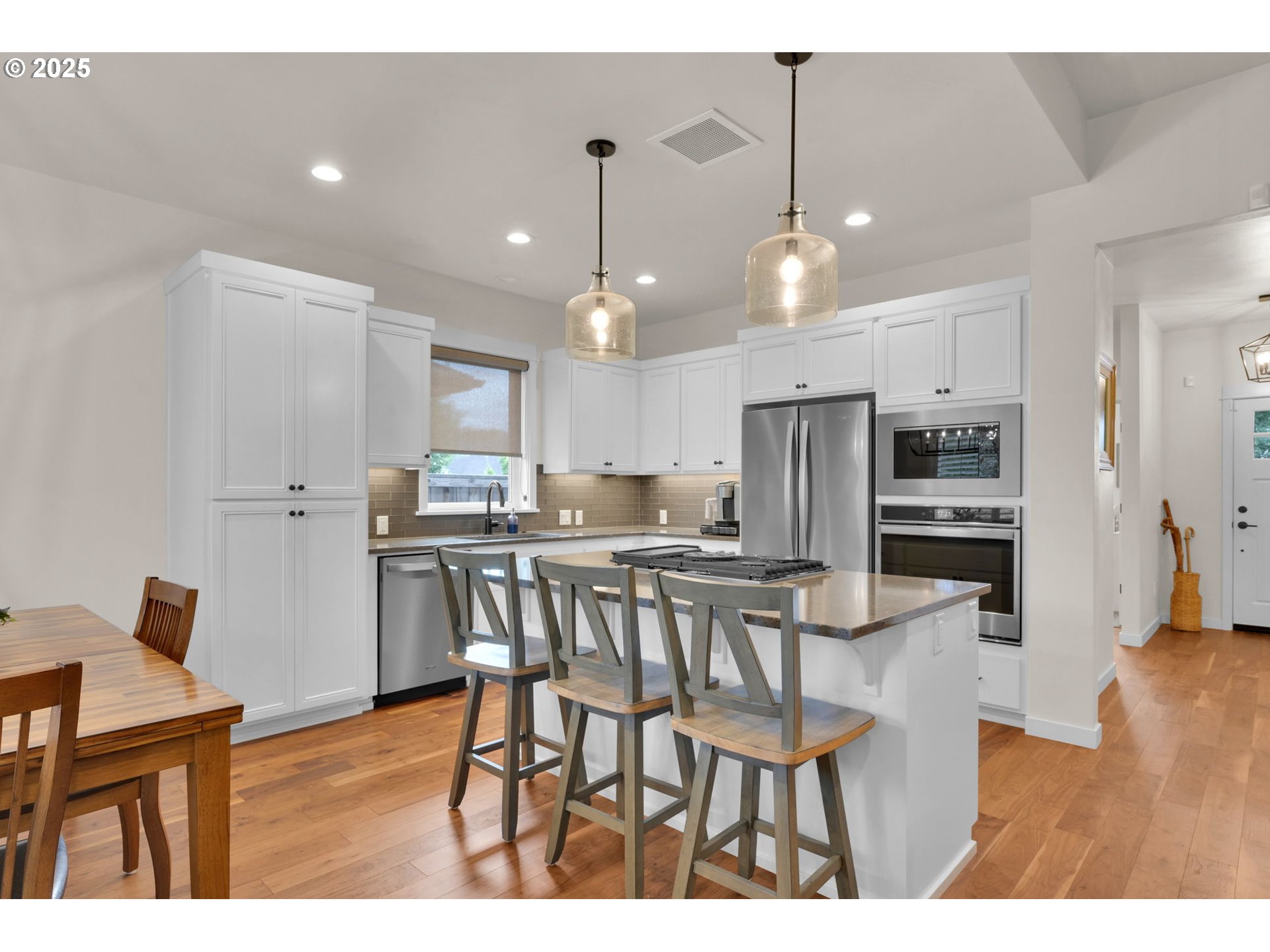 970 Lupine Street Springfield, OR 97477 - Photo 19 of 47 a kitchen with stainless steel appliances kitchen island granite countertop a dining table chairs and a refrigerator