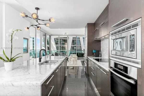 a kitchen with stainless steel appliances granite countertop a sink a stove and cabinets