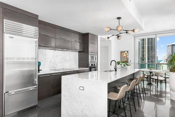 a kitchen with stainless steel appliances granite countertop a sink and a refrigerator