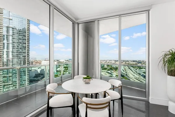 a view of a city from a dining room with a table and chairs
