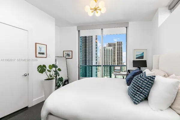 a bedroom with a bed table and chairs