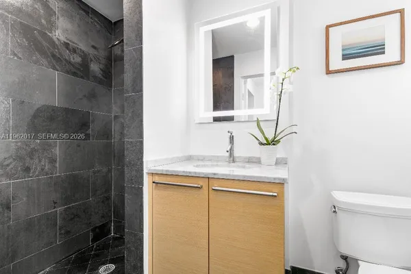 a bathroom with a granite countertop sink a toilet and a mirror