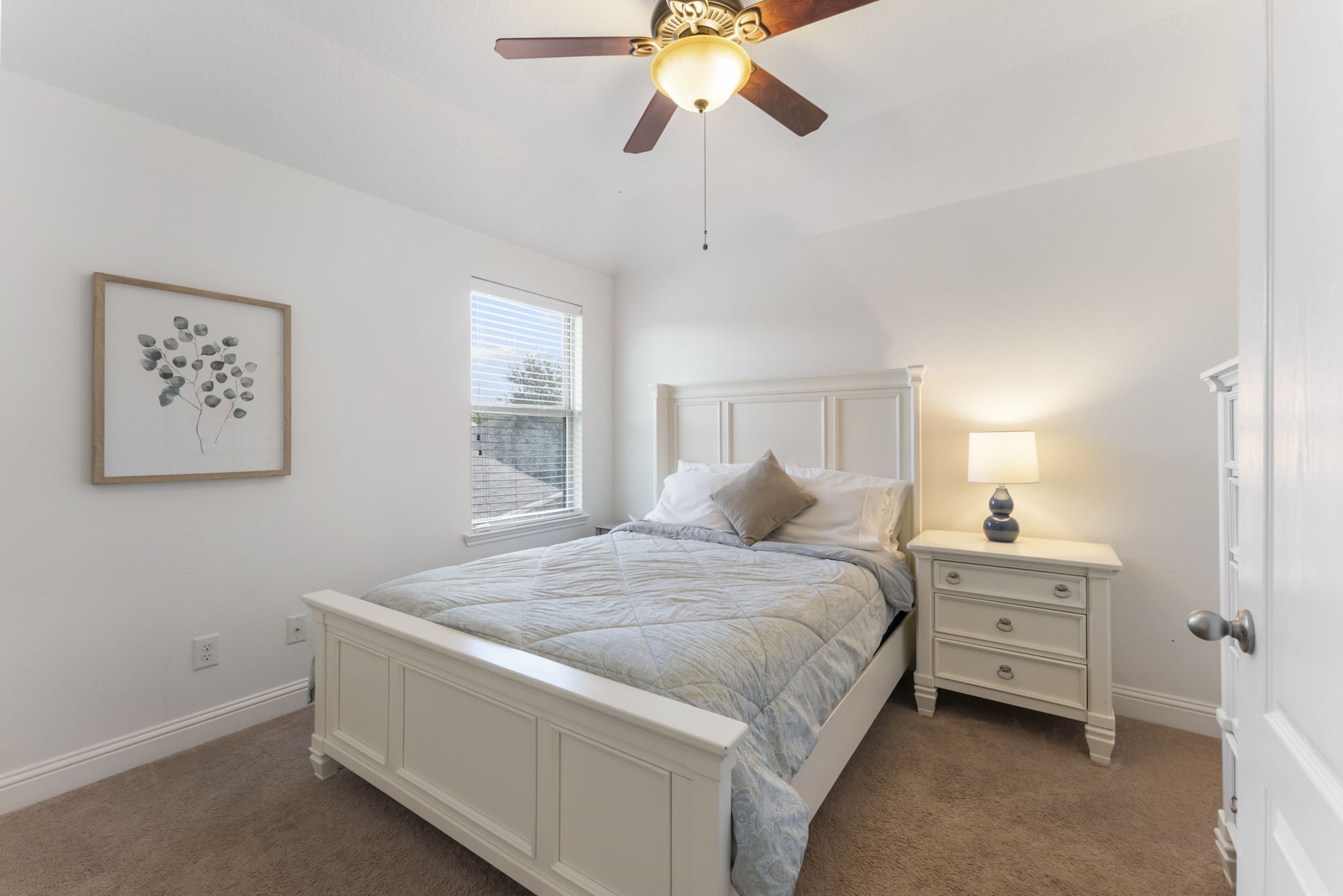 119 Wood Drake Place Tomball, TX 77375 - Photo 30 of 47 a bedroom with a bed and a chandelier