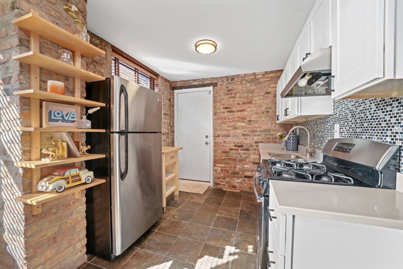 464 North Aberdeen Street, Unit 1R Chicago, IL 60642 - Photo 2 of 16 a kitchen with stainless steel appliances a refrigerator and a sink
