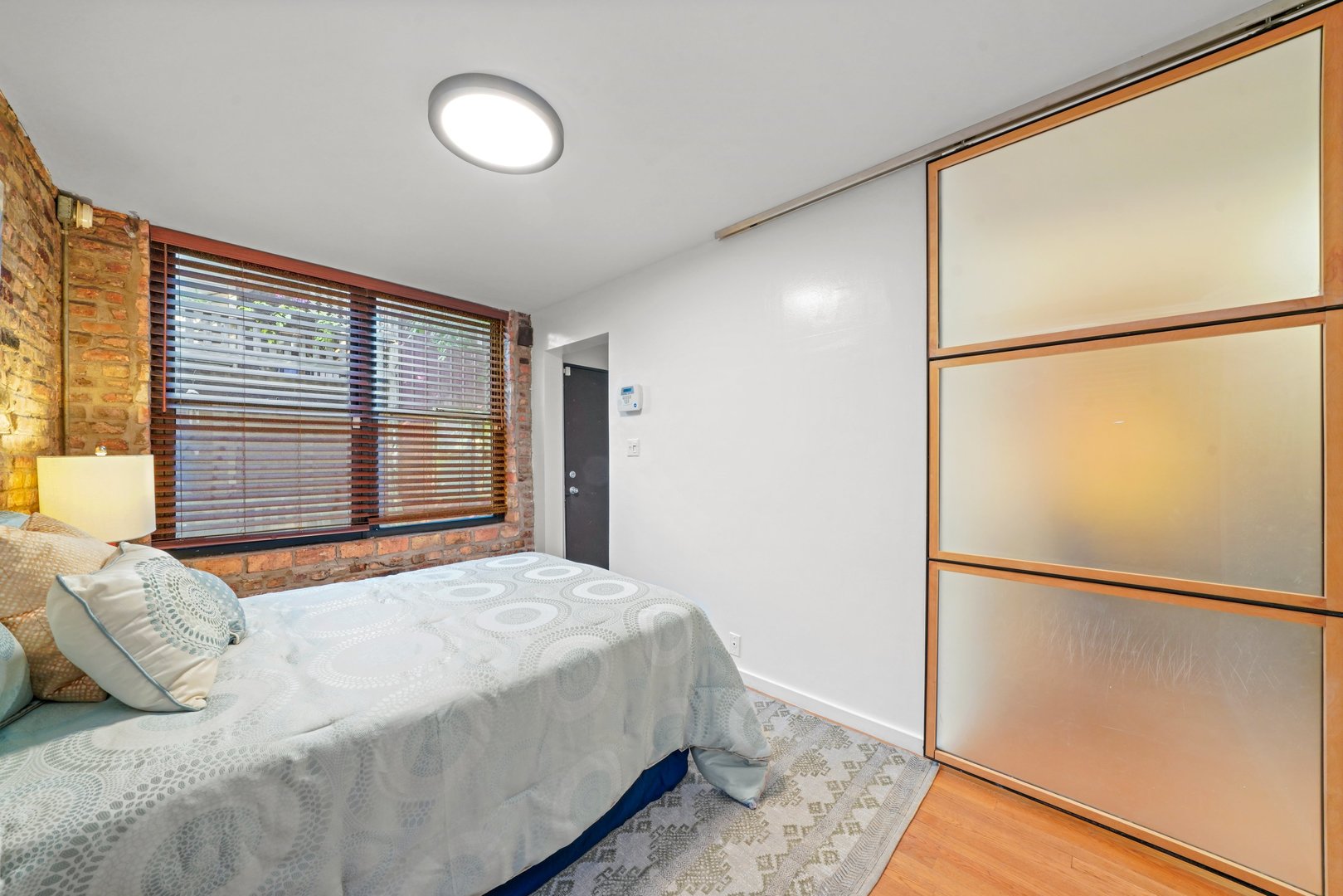 464 North Aberdeen Street, Unit 1R Chicago, IL 60642 - Photo 8 of 16 a bedroom with a bed and a window