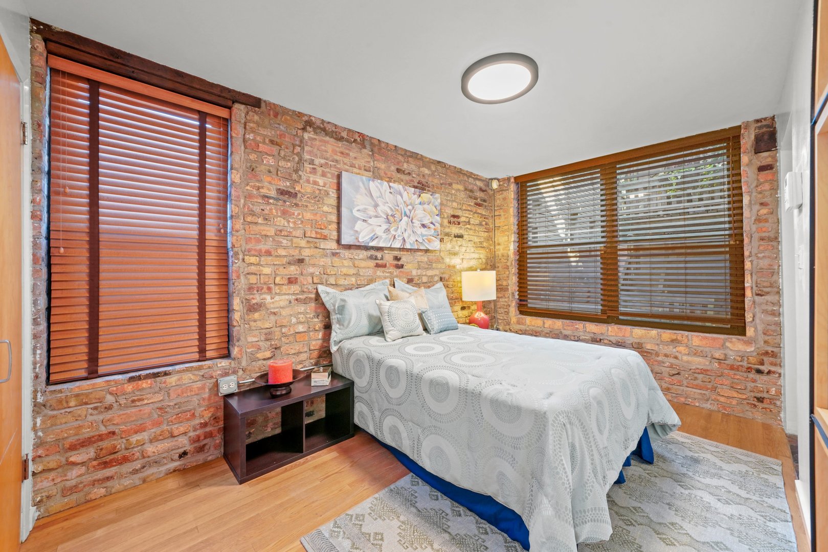 464 North Aberdeen Street, Unit 1R Chicago, IL 60642 - Photo 9 of 16 a bedroom with a bed lamp and a large window
