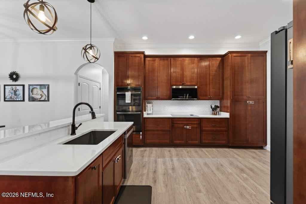 37575 Kings Ferry Road Hilliard, FL 32046 - Photo 34 of 83 a kitchen with kitchen island granite countertop a sink and wooden cabinets