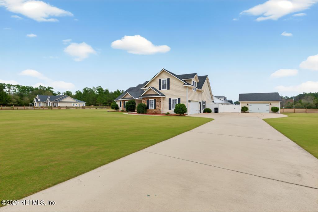 37575 Kings Ferry Road Hilliard, FL 32046 - Photo 4 of 83 a view of house with a yard and potted plants