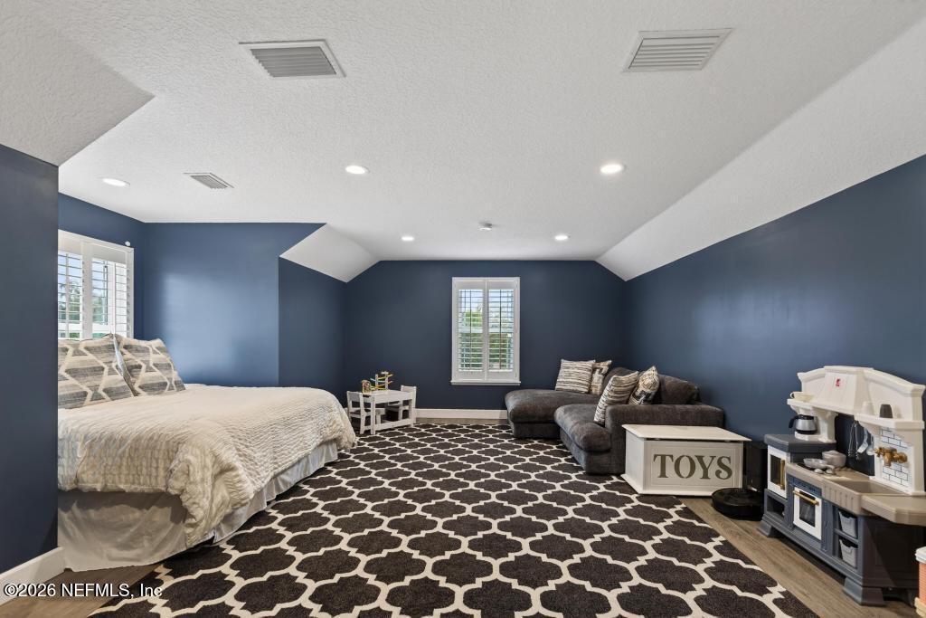 37575 Kings Ferry Road Hilliard, FL 32046 - Photo 49 of 83 a bedroom with a bed and a lamp on dresser