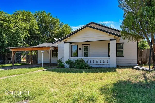 a view of a house with a yard and porch