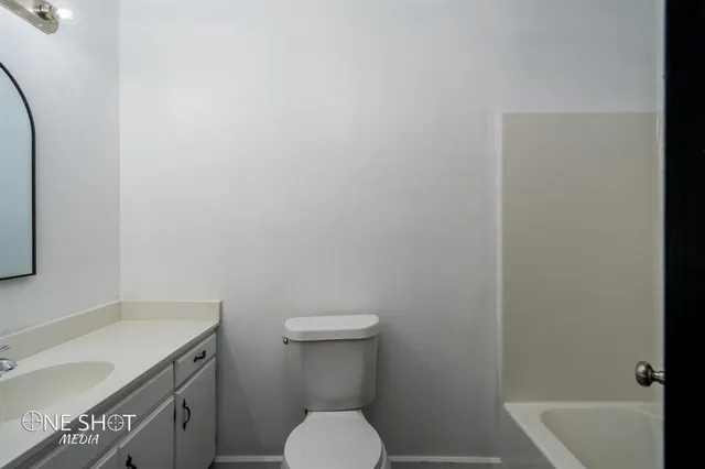 a bathroom with a granite countertop toilet and sink