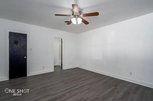 a view of an empty room with wooden floor