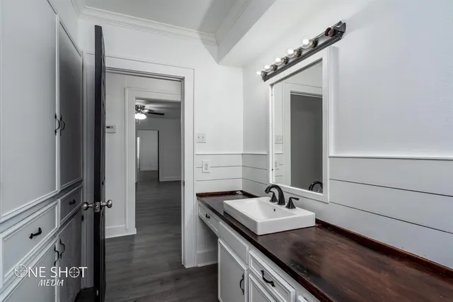 a en suite bathroom with a granite countertop sink and a mirror