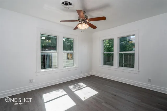 a view of wooden floor and a chandelier fan in a room