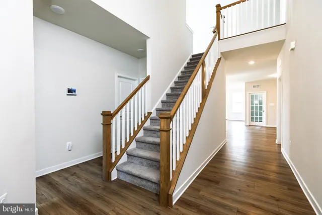 a view of a hallway with wooden floor and staircase